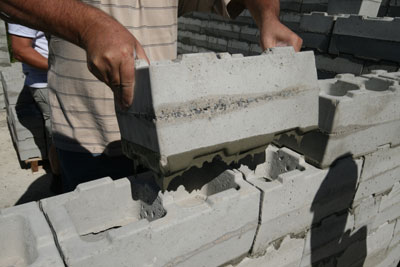 Dipping a Stumbelbloc into BlockGrip adhesive before laying